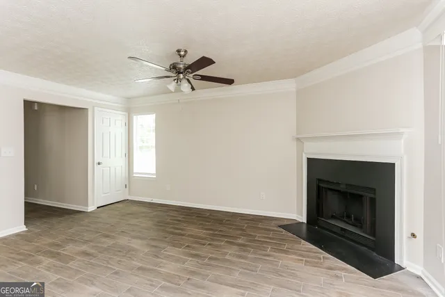 a view of an empty room with a fireplace and a window