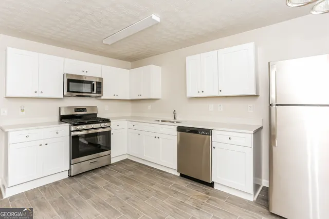 a kitchen with granite countertop white cabinets and white appliances