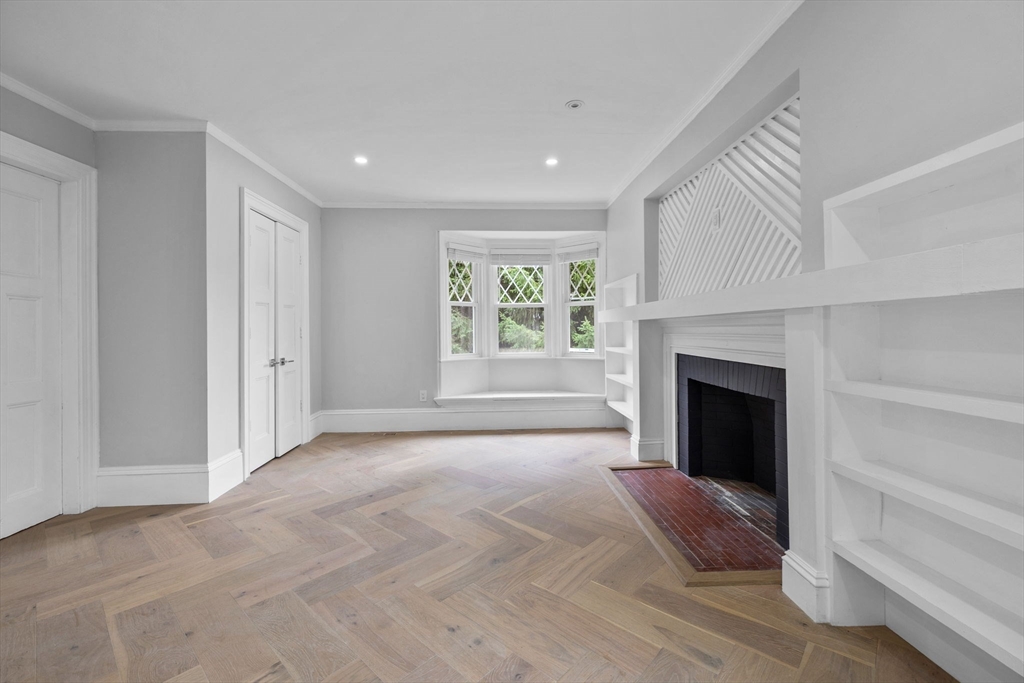 476 Heath Street Brookline, MA 02467 - Photo 17 of 41 a view of an empty room with window and fire place