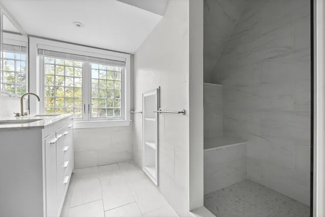 a bathroom with a granite countertop toilet sink and mirror