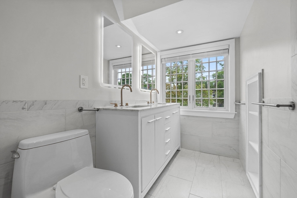 476 Heath Street Brookline, MA 02467 - Photo 35 of 41 a bathroom with a granite countertop toilet sink and mirror