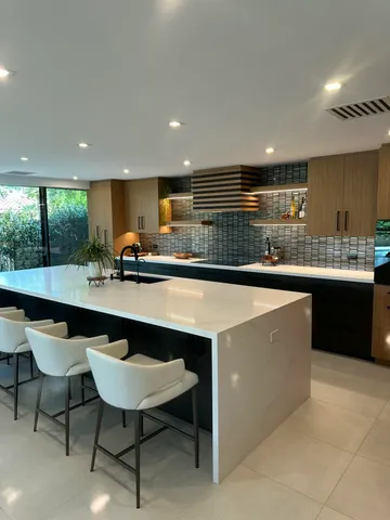 a kitchen with stainless steel appliances a sink a counter top space cabinets and a large window