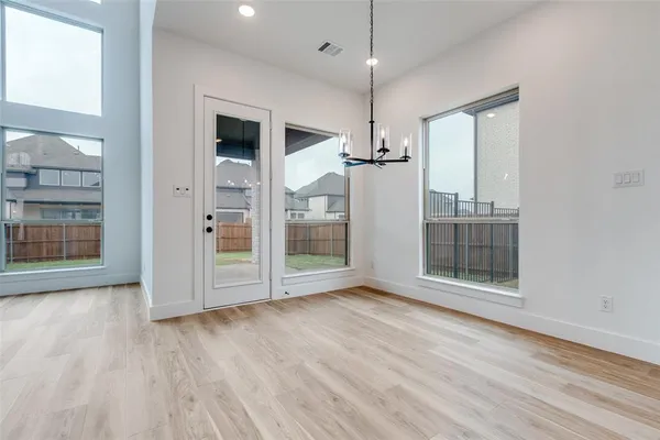 an empty room with wooden floor wooden floor and windows