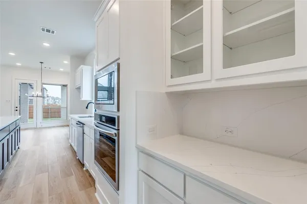 a kitchen with a refrigerator and a stove top oven
