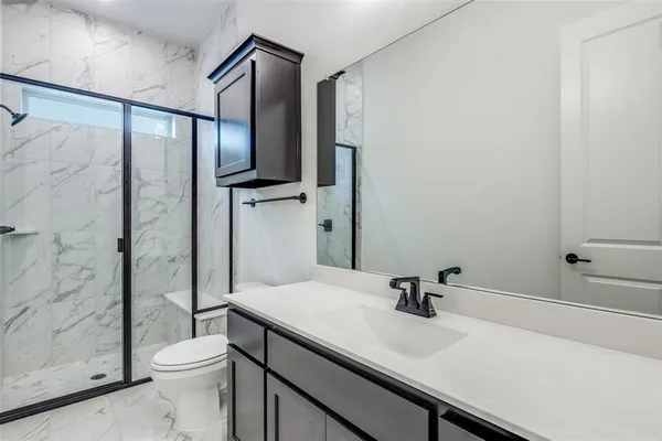 a bathroom with a sink a toilet and shower