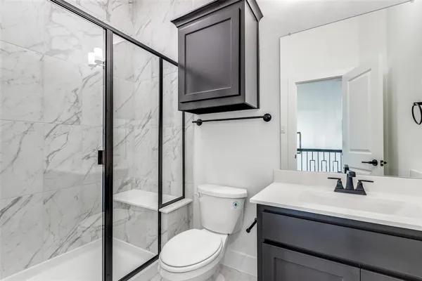 a bathroom with a sink a toilet and shower