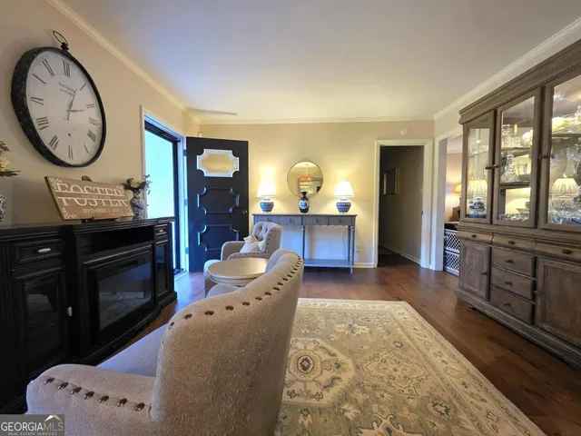 a living room with furniture a clock on wall and a window