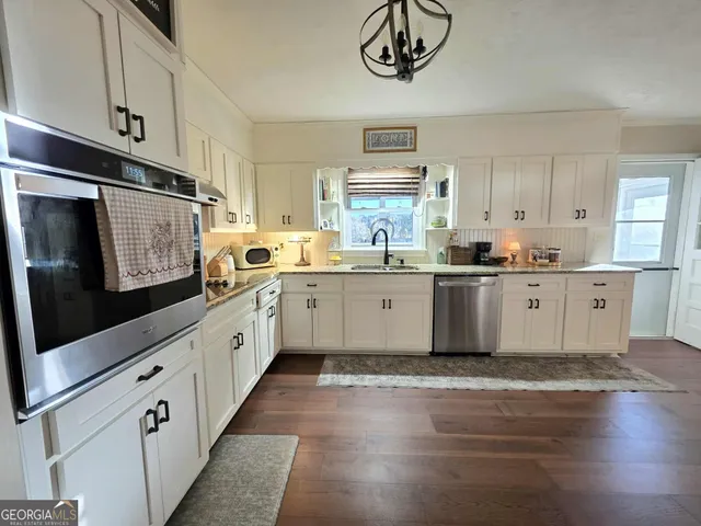 a kitchen with stainless steel appliances a sink a stove a microwave and cabinets