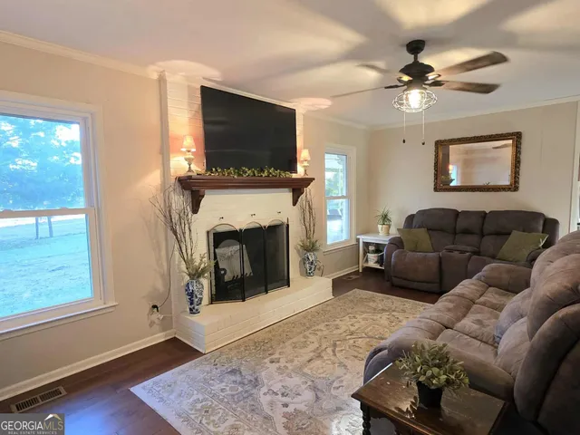 a living room with furniture a flat screen tv and a fireplace