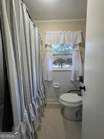 a bathroom with a sink a toilet a window and tub