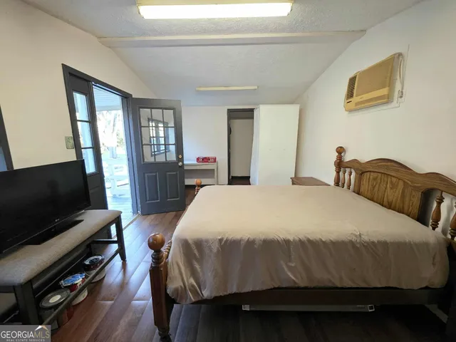 a bed sitting in a bedroom next to a window with pc on the table