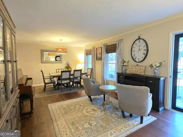 a living room with furniture a clock on wall and a table