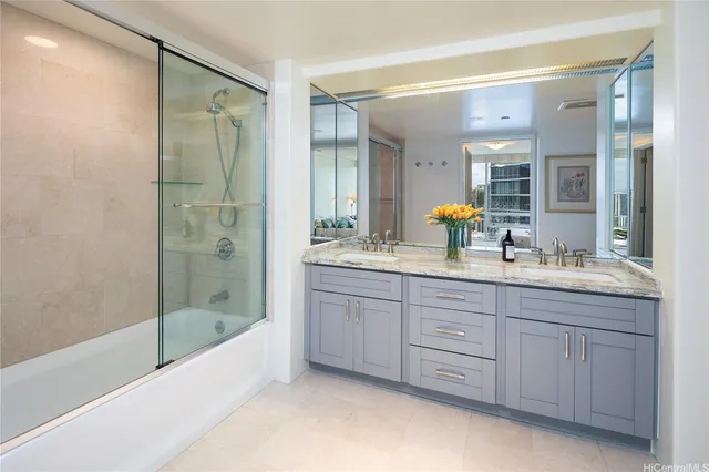 a bathroom with a granite countertop sink mirror bathtub and shower