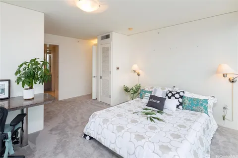 a bedroom with a bed and a potted plant