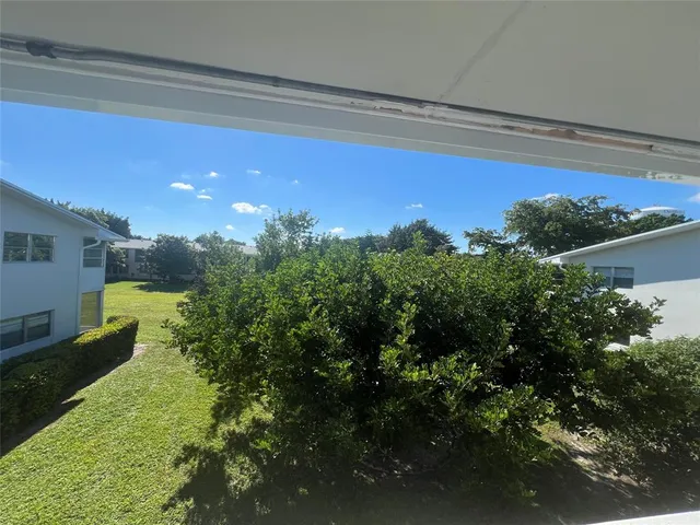 a view of a fountain in front of a house with a yard