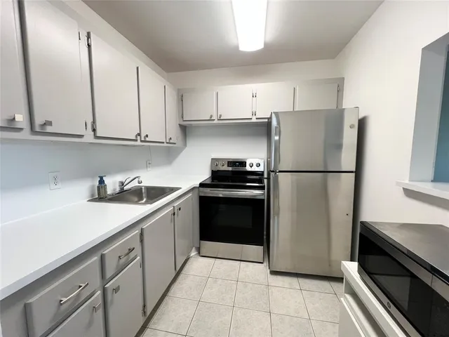 a kitchen with a refrigerator sink and cabinets