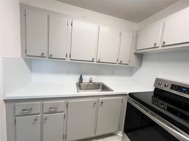 a kitchen with white cabinets and a stove