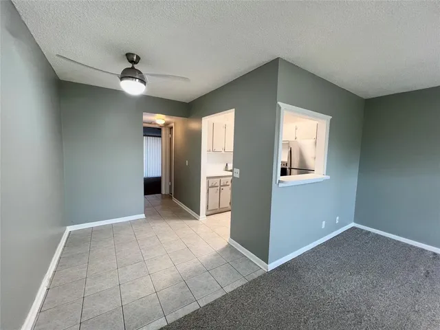 a view of an empty room with window and cabinet