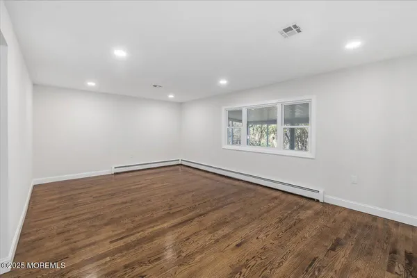 a view of empty room with wooden floor