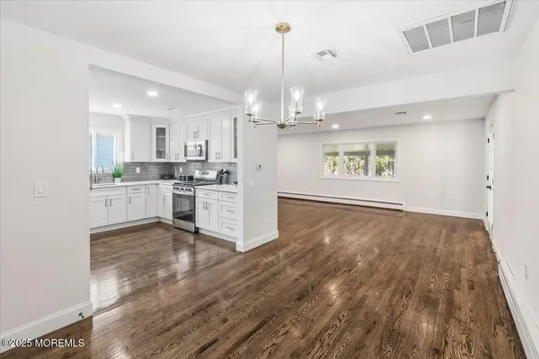 a kitchen with stainless steel appliances wooden floor and cabinets