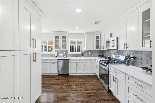 a kitchen with white cabinets and white appliances