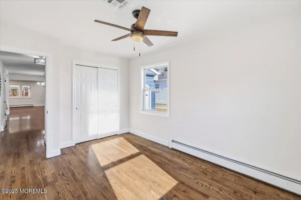 a view of empty room with wooden floor