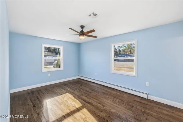 a view of an empty room and window and wooden floor