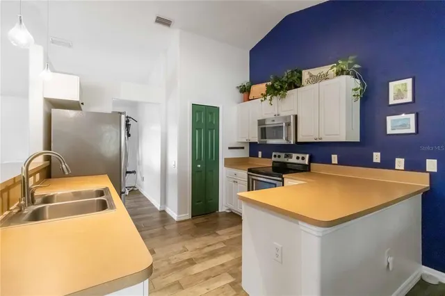 a view of a kitchen with a sink dishwasher stove and refrigerator