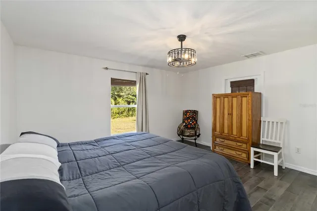 a bedroom with a bed and a table chair