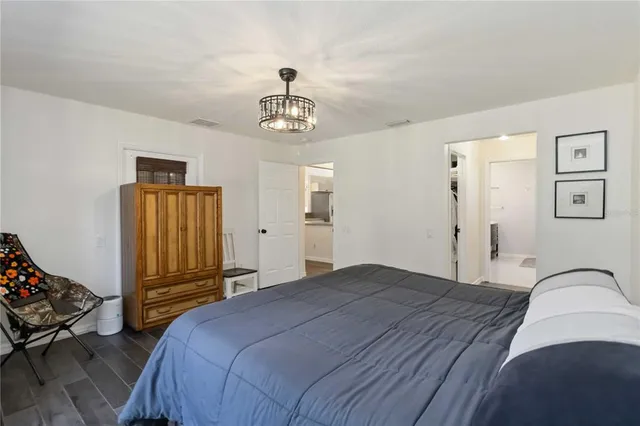 a bedroom with a bed and dresser with mirror