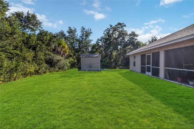a view of a backyard with potted plants and large trees