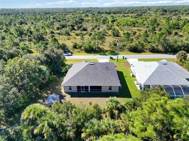 an aerial view of a house with a yard and swimming pool