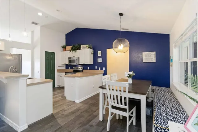 a kitchen with cabinets and wooden floor