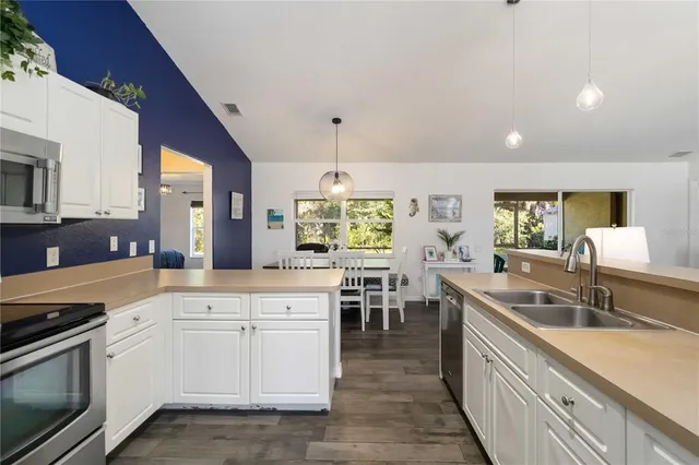 a kitchen with white cabinets and sink