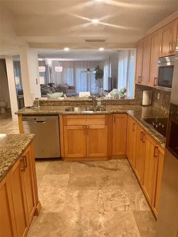 a kitchen with stainless steel appliances granite countertop a sink stove and cabinets