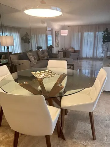 a living room with furniture a lamp and a dining table