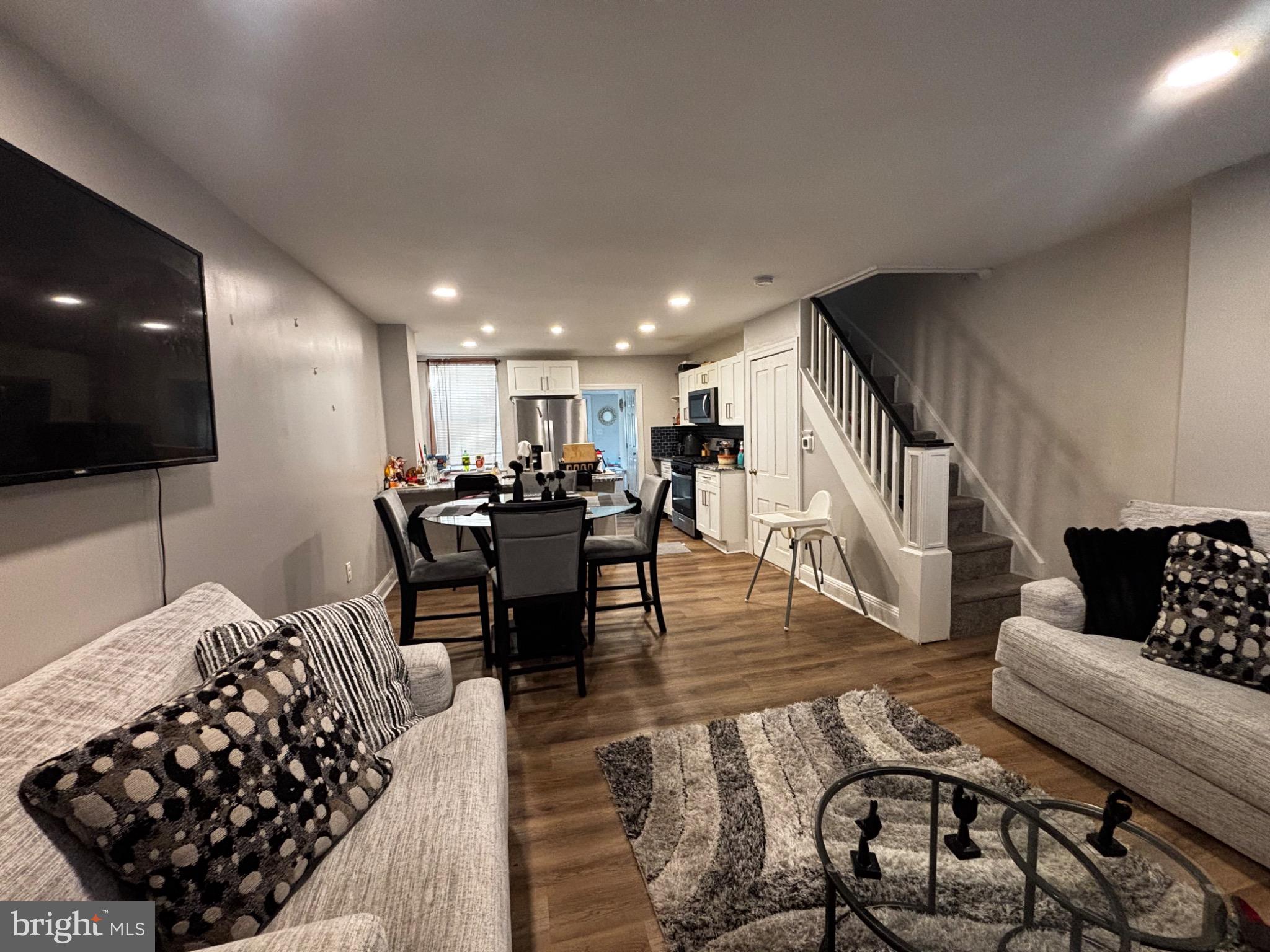 a living room with furniture and wooden floor