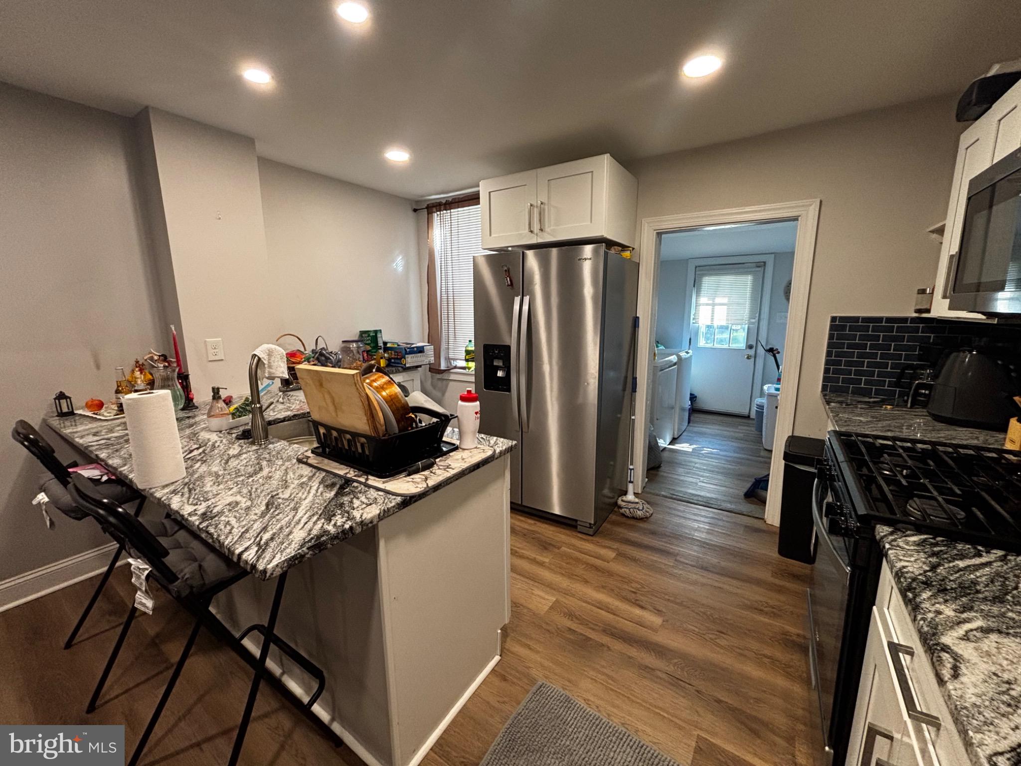 4 3rd Street Brookhaven, PA 19015 - Photo 8 of 21 a kitchen with stainless steel appliances kitchen island granite countertop a table chairs and a refrigerator