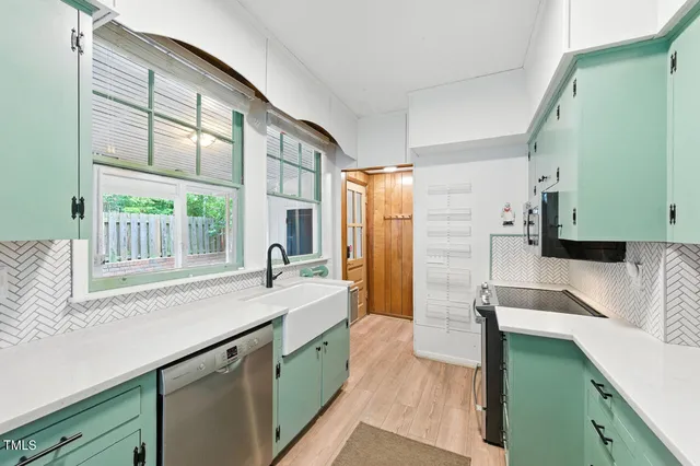 a kitchen with granite countertop a sink a counter top space and stainless steel appliances