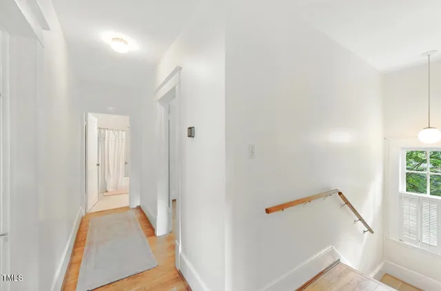 a view of a hallway to rooms and stairs