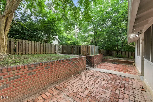 a view of a backyard with a small cabin and wooden fence