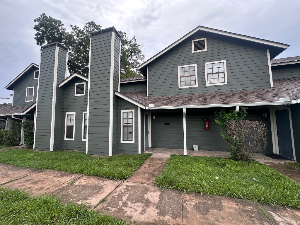 1007 Water Street, Unit 104 Bastrop, TX 78602 - Photo 2 of 23 a front view of a house with garden