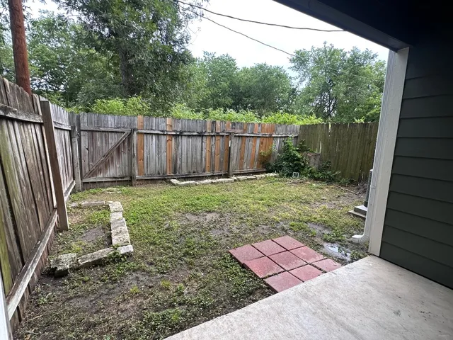 a view of a backyard with a small cabin and wooden fence