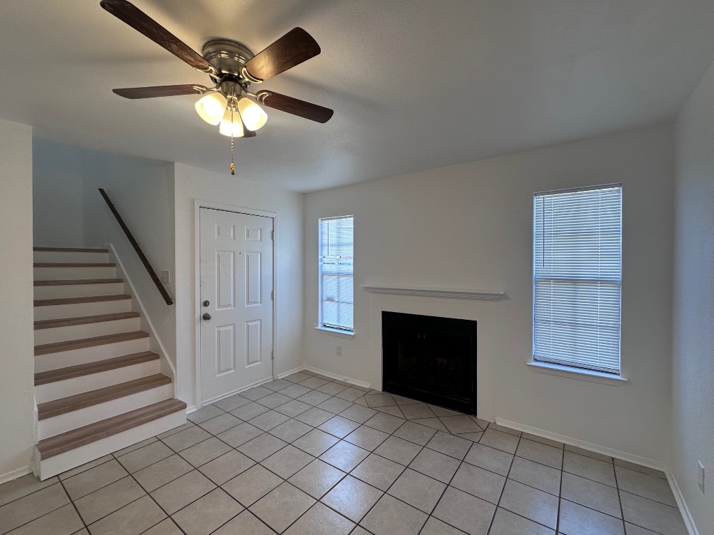 1007 Water Street, Unit 104 Bastrop, TX 78602 - Photo 5 of 23 an empty room with windows fireplace and fan