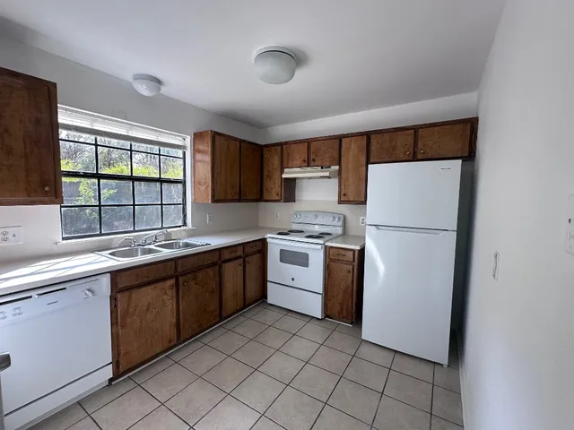 a kitchen with a refrigerator sink and cabinets