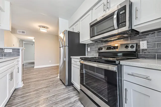a kitchen with stainless steel appliances a refrigerator and a stove top oven