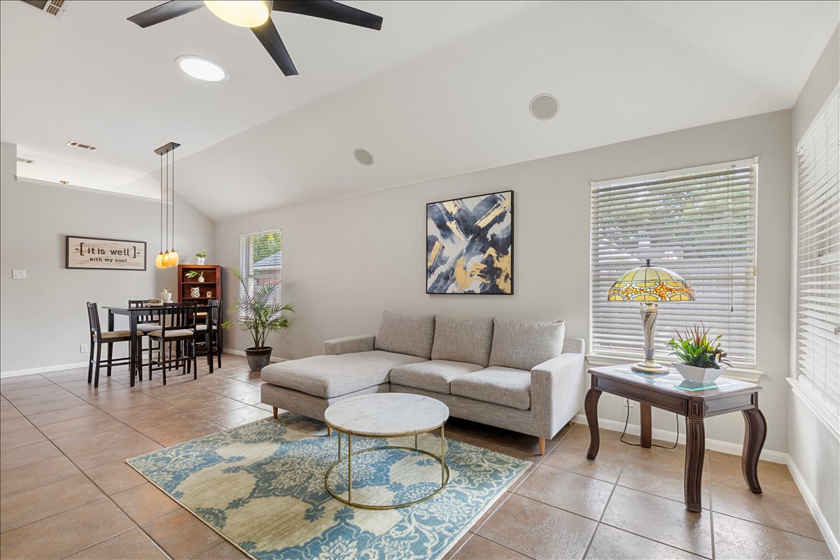 9012 Meacham Way Austin, TX 78749 - Photo 14 of 34 Open-concept living space featuring vaulted ceilings, tile flooring, and neutral wall tones
