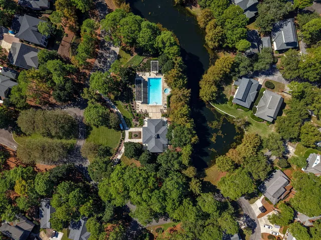 an aerial view of residential houses with outdoor space and lake view