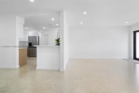 a view of a kitchen with refrigerator and wooden floor