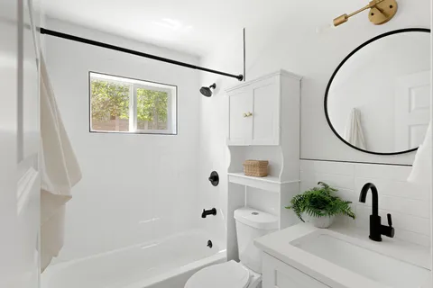 a bathroom with a sink a toilet and a mirror